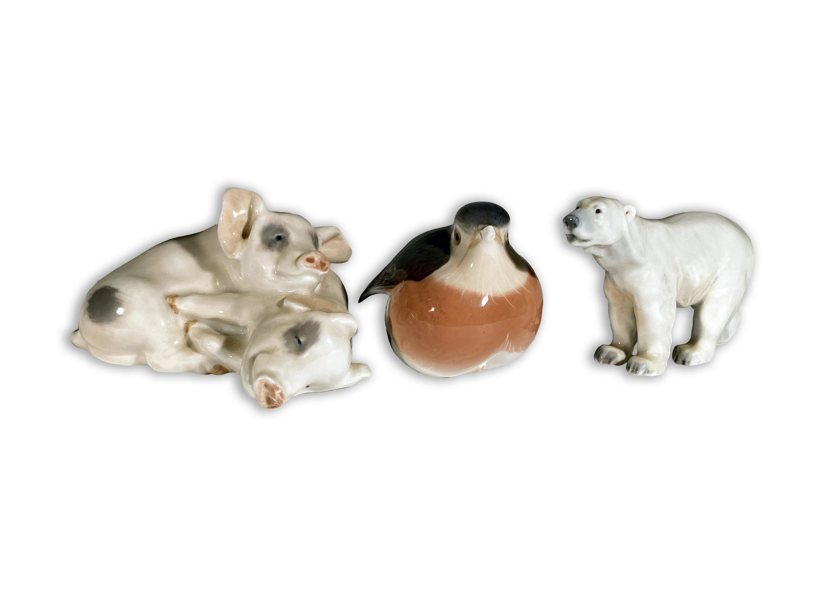Three Royal Copenhagen Porcelain Animals: Three (3) Royal Copenhagen Porcelain Animals Royal Copenhagen #683 a pair of piglets. Royal Copenhagen #2266, bird with beak partially broken off. Royal Copenhagen #113-(?), polar bear. Piglets are 4.