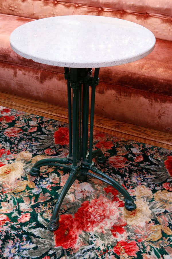 Set of Four Café Tables from the Tavern's Bar: Four café round café tables with graceful cast iron bases and granite tops. H28", dia. 20"