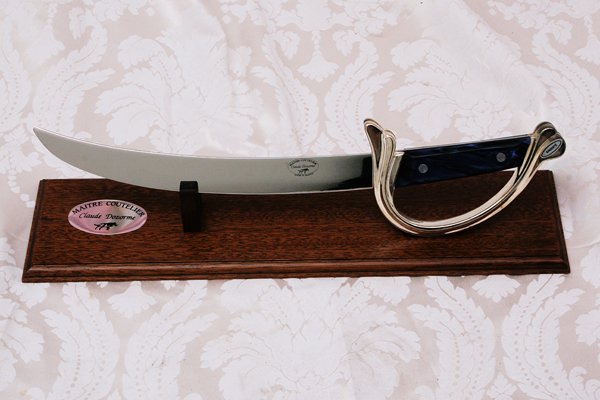Decorative Sword in Wood Display Stand: Decorative metal sword marked "Maitre Coutelier", in wooden display stand. A favorite of Warner LeRoy. Approx. 22"