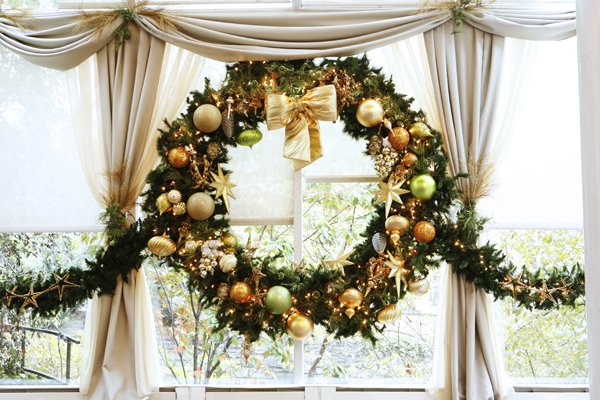 Giant Green and Gold Christmas Wreath: A giant Christmas wreath composed of green and gold-color decorative balls with ribbons and festoons.