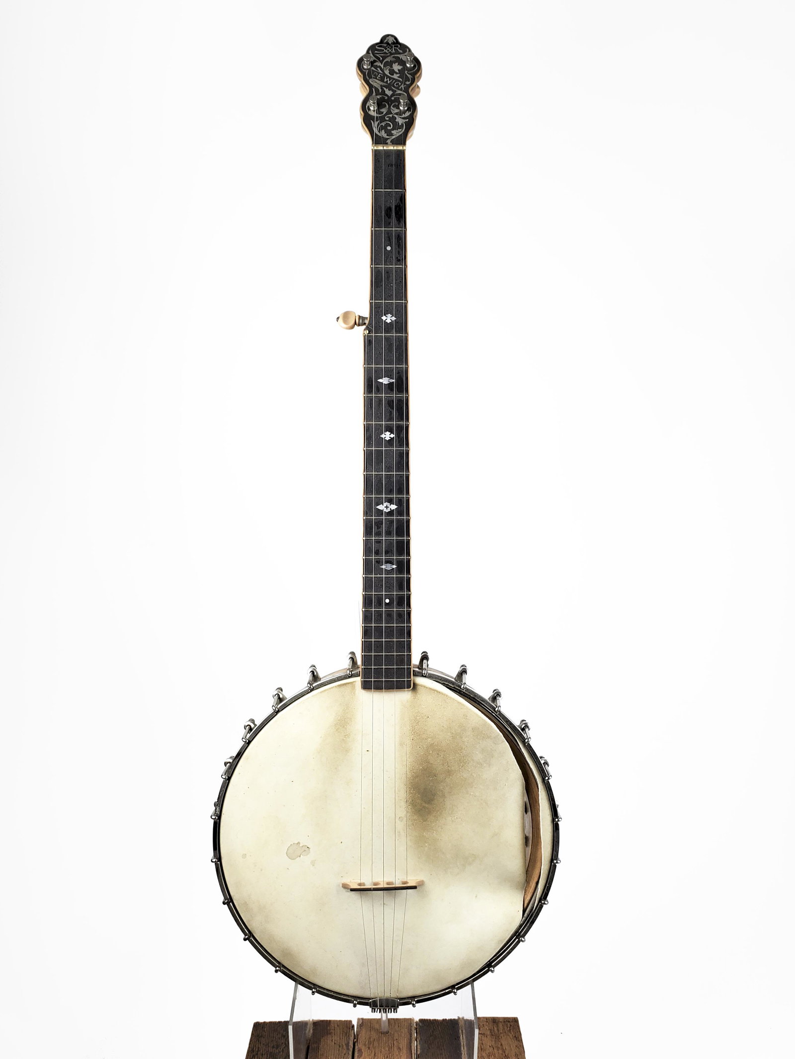 DeWick Banjo: DeWick Banjo S & R DeWick. Beautiful inlay on inner and outer rim. Head ripped. Length: 95cm. William H. DeWick was a respected music teacher and instrument maker from the 1890s to the 1920s, known mo