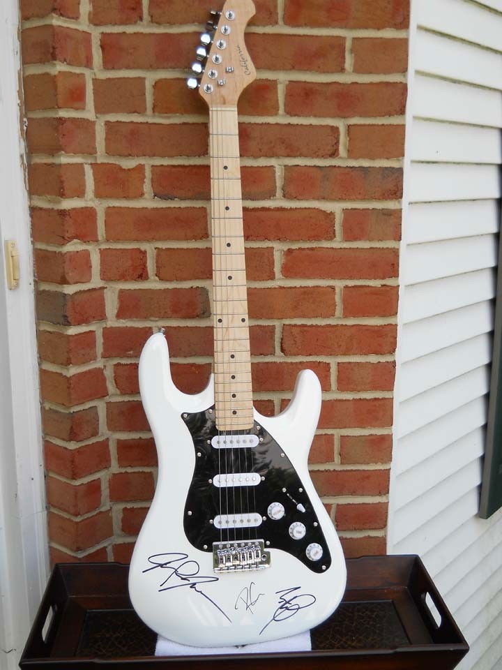 Led Zeppelin Signed White Electric Guitar: A white California electric guitar signed by Jimmy Page, John Paul Jones, and Robert Plant in New York City on September 27, 2006. It comes with a certificate of authenticity.
