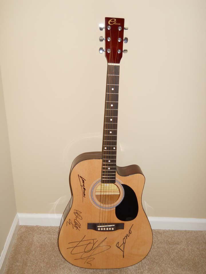 U2 Signed Natural Ash Accoustic Guitar : Natural ash finish acoustic guitar signed by Bono, The Edge, Adam Clayton, and Larry Mullen Jr. as part of a fund raising effort. Included is a certificate of authenticity.