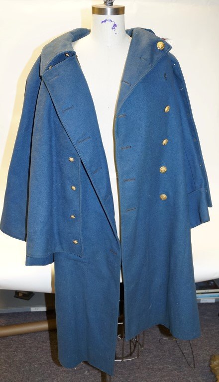 Vintage Clothing Lot: 1880's Ladies lace bed jacket; tan & brown two-piece dress; black "gamblers" vest; blue wool military jacket with cape. Cape is lined in yellow wool. Brass buttons decorated with eagle, shield & stars