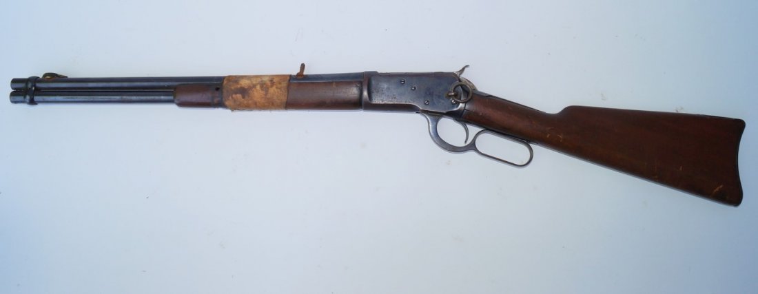Winchester 1892 Trapper's Carbine: 38 W. C. F. calibre Barrel band missing. Barrel and fore end repaired with leather and brass tack. Condition good. Marked Los Animos Cty. Deputy Trinidad and RA & LO within a five pointed star carved 