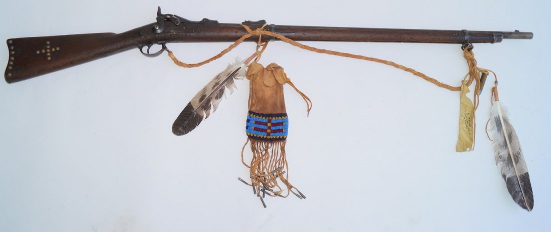 1873 Model Springfield Trapdoor Rifle: W.B. 32321 45-70 calibre . Made in 1885. Indian Rifle. Brass tack decorations. Decorated with hand painted eagle feathers attached with trade beads.. Well beaded ammunition pouch with tin decorations.