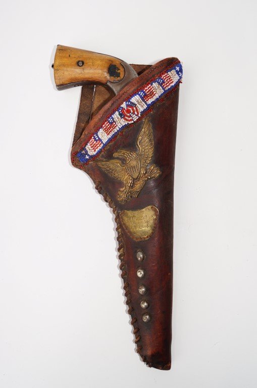 Merwyn & Hulbert Revolver: 44 calibre W. C. F. Serial Number 606737. In a leather holster with bead tack decorations and an applied high relief brass eagle. Bead work band. Brass plaque reading "U. S.Army Indian Scout Interpret