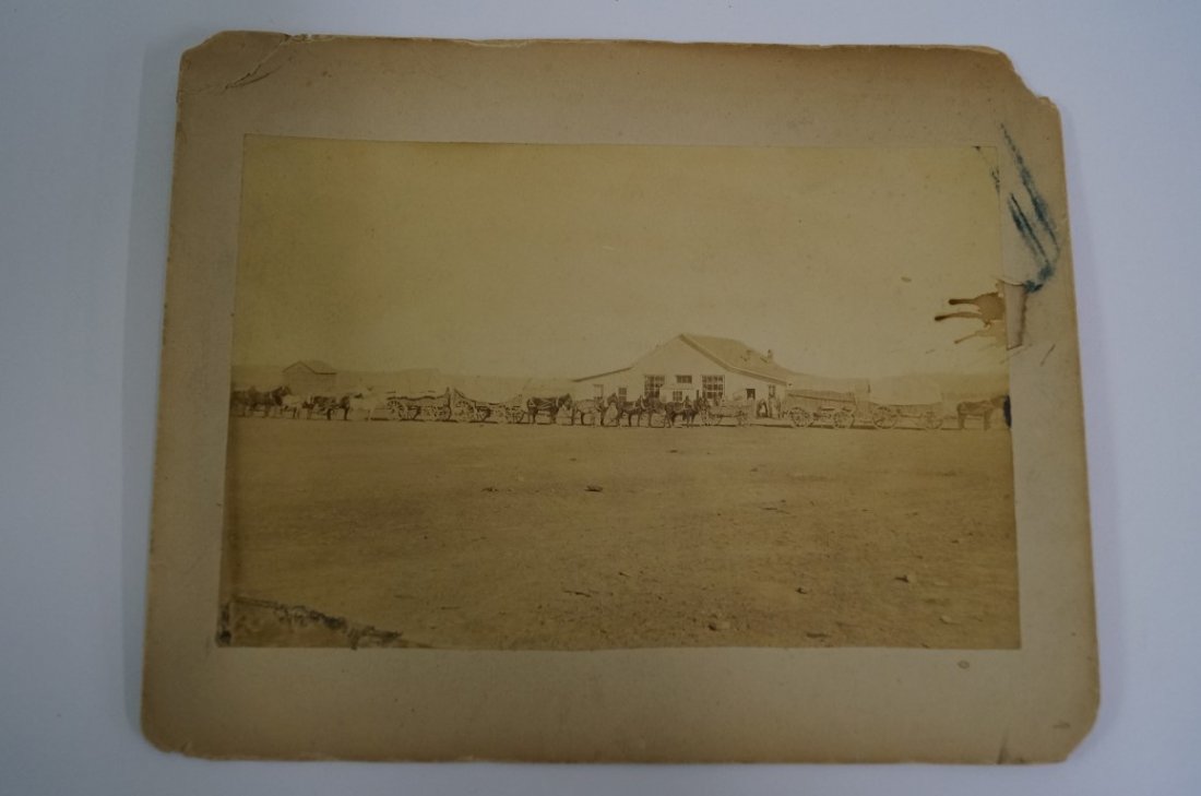 Indian Traders at Fort Washakie Photo: Albumen photograph shows wagons and teams,men & trding post, with reverse ink identification "Indian Traders store and freight train in from the UPRR Ft. Washakie, Wyoming. C. 1880's 8" x 10" mat corn