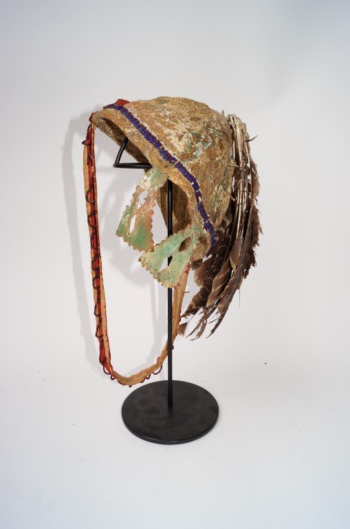 Indian Hide Cap: With beadwork, feather and paint decorations. Chin strap.