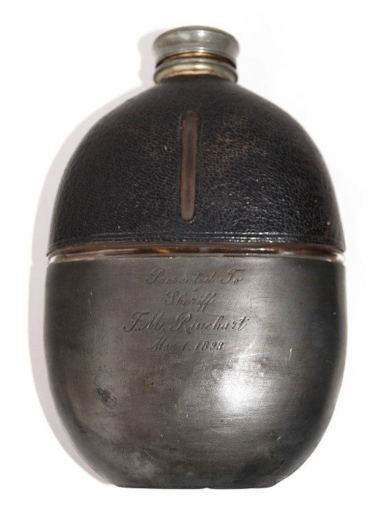 Presentation Flask: James Dickson & Son. Scheffield cover to the glass leather mounted flask. Inscribed Presented to Sheriff F.M. Rinehart, May 1, 1898. 6-1/4" H.