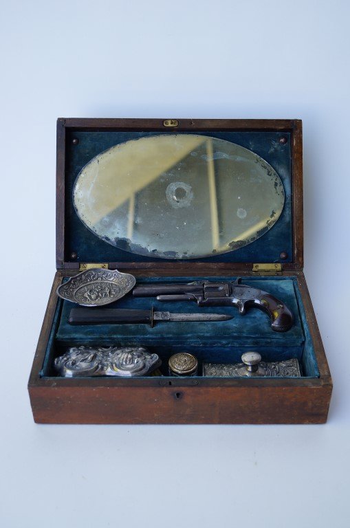 Alice Ivers Gun/Dressing Table Box: Marked Alice Ivers at the top. Contains a pistol, knife, silverplated brush, tray, roller blotter and a glass inkwell with a silver top. Alice may have been a "smoking" lady. Also contains cigars, mat