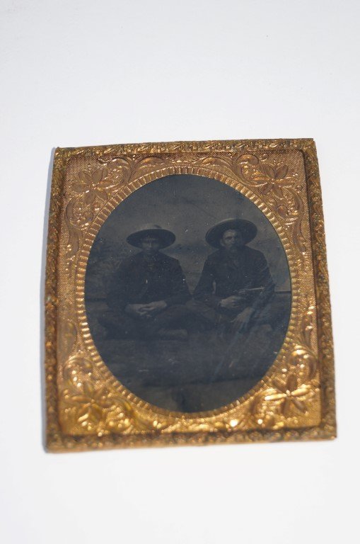 Tintype Two Cowboys: Late 19th C. tintype of two cowboys in a daguerreotype inner frame. Two men with wide brimmed cowboy hats sitting on a bale of hay.With revolvers. 3 1/4" x 2 3/4"