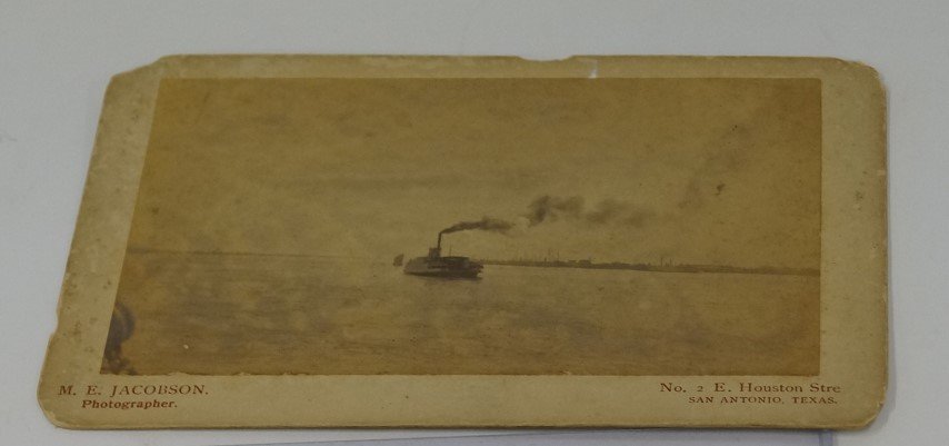 M. E. Jacobson Ferry Boat Photograph: Ferry boat photograph by M. E. Jacobsen, photographer. No. 2 Houston Street, San Antonio, Texas. On a larger cream colored mount. Margins nipped into as will be visible in the photo.