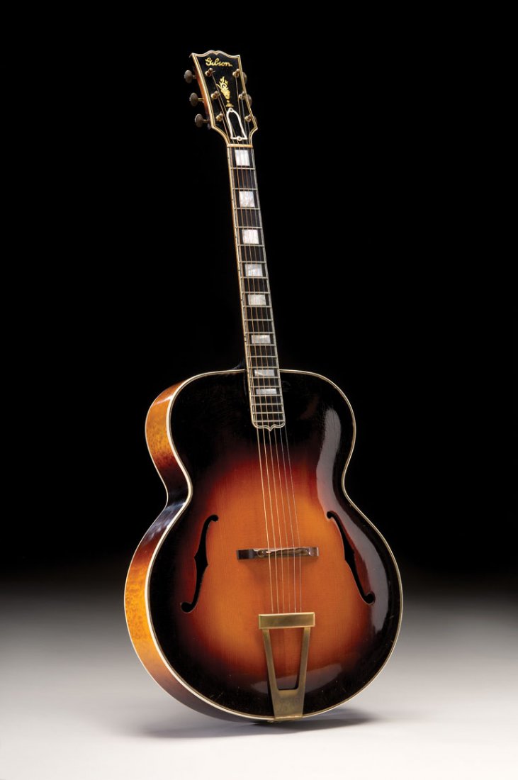 1936 Gibson L-5: This 1936 L-5 features the flat plate engraved “L-5” trapeze tailpiece and other attributes typical of models produced during this year. The maple back is noteworthy for the distinctive quilted fi