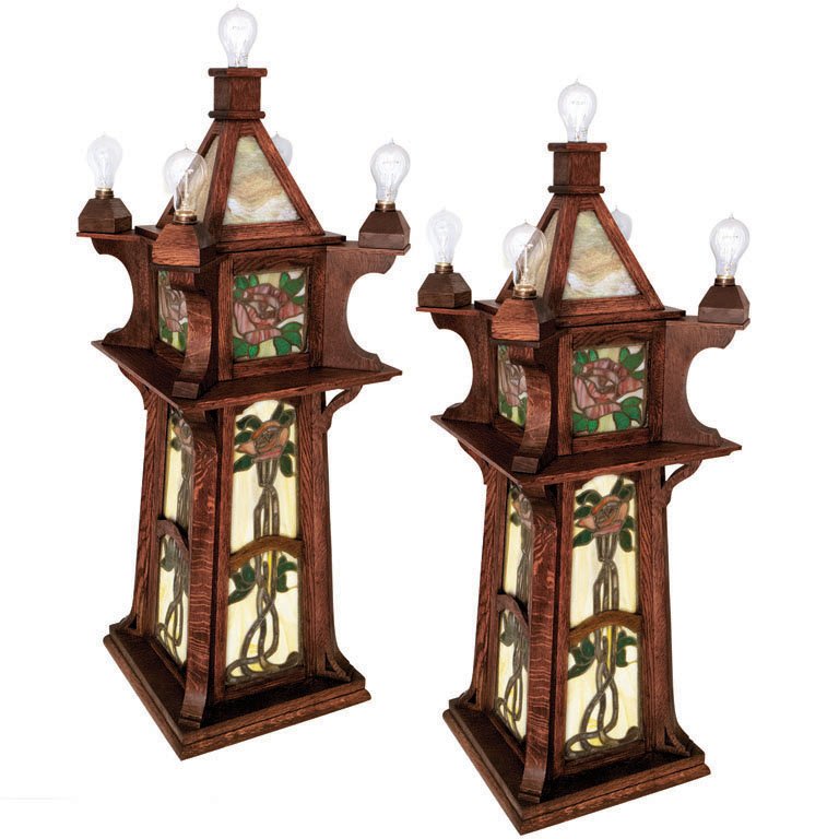 ONE PAIR OF ART NOUVEAU STAINED GLASS LIGHTS, C. 1910: Each light is adorned with beautiful stained glass complete with a rose and vine motif, framed by richly colored oak with handsomely striped grain in multiple areas. Sold in fine, original condition.