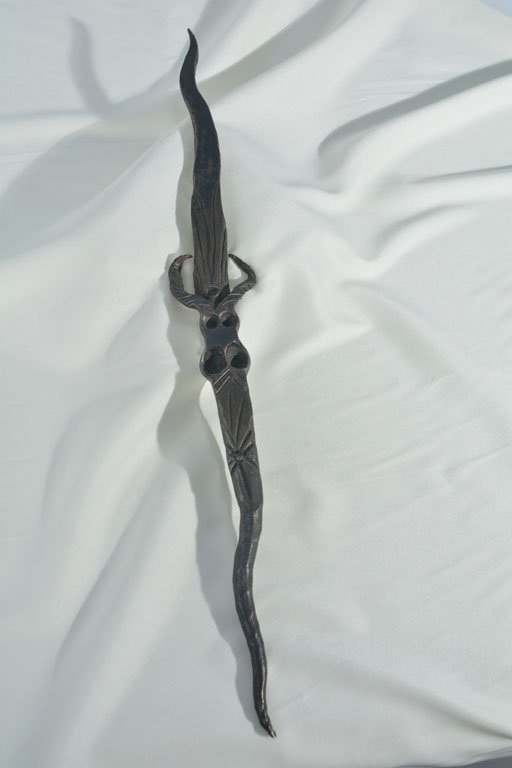 Carved Metal Staff: Johnny was partial to interesting metal objects, like unique knives, razors, and staves. He used this strange curved staff, with its carved face and gemstone, to stoke the fire. 8.5" length.