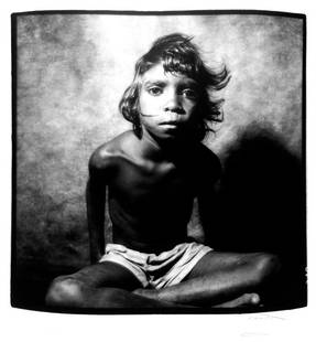 William Coupon (b. 1952): Note: Description Updated 11/21. Aboriginal Australian Boy. B&W, c. 1980. Mounted, fiber-based vintage Type "C" print. Portrait of an Aboriginal Australian boy, in shorts, sitting with his legs crosse