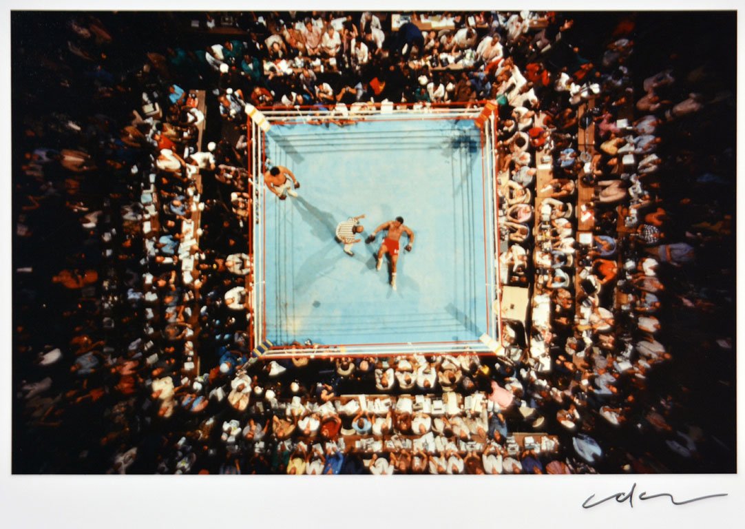 Ali v. Foreman Knockout: Note: Description Updated 11/22. Color, c. 1974. Type "C" older print. Dramatic bird's-eye view of the ring with a fallen Foreman and a victorious Ali, and the throngs of people surrounding them. Sign
