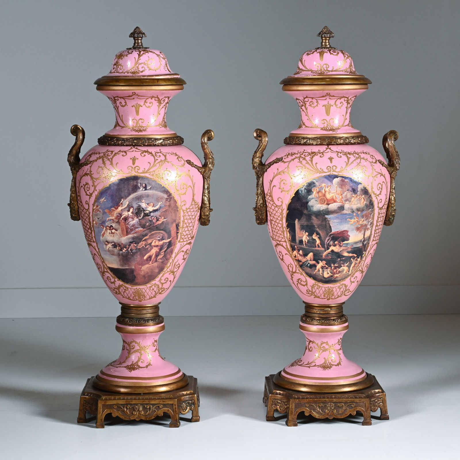 A pair of large French gilt bronze mounted, pink ground Sevres porcelain vases, signed Gilbert and: A pair of large French gilt bronze mounted, pink ground Sevres porcelain vases, signed Gilbert and bearing the Sevres mark on the inside of the lidEen paar Grote Franse vergulde bronzen vazen met roze