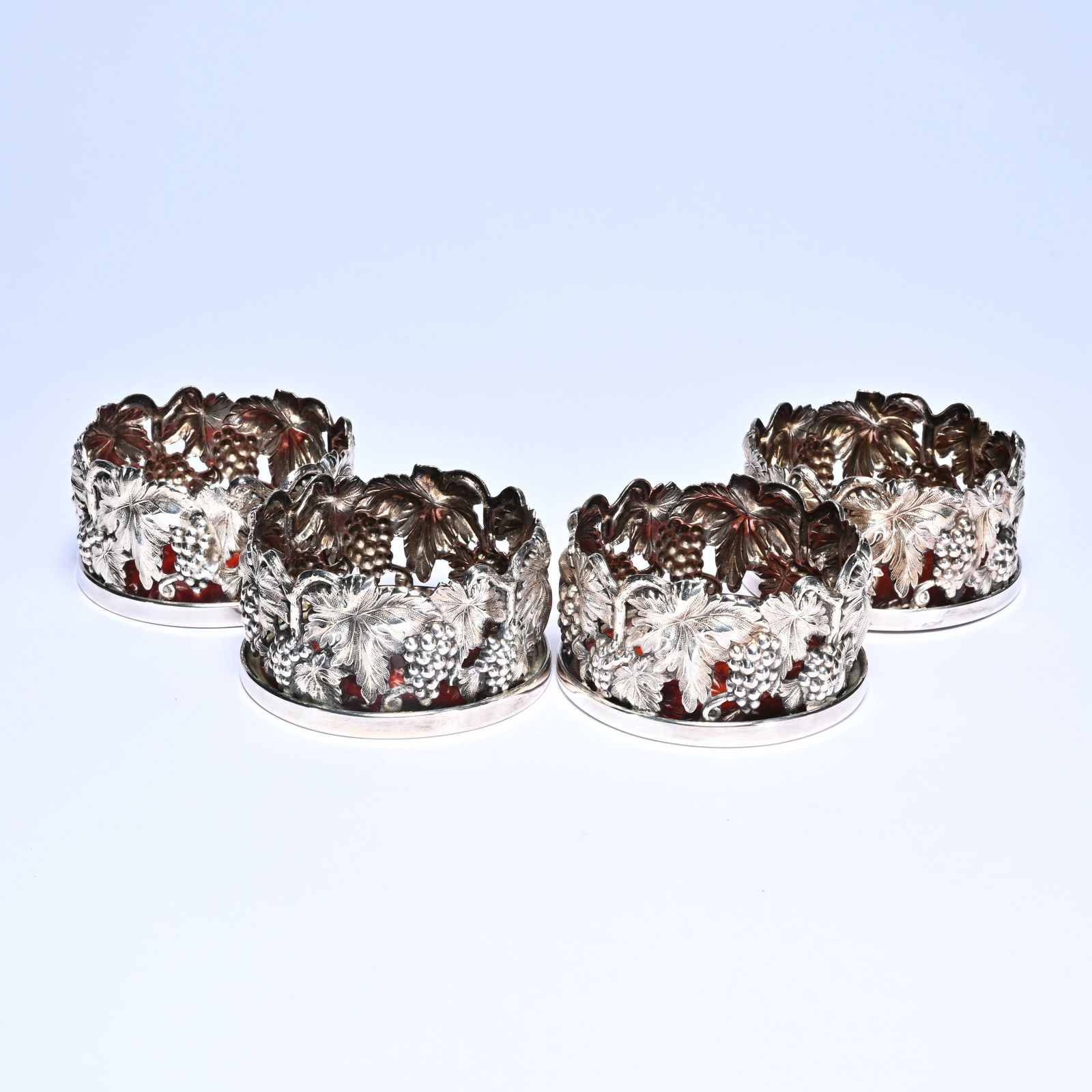 Four silver-plated bottle holders, decorated with grapes and leaves: Four silver-plated bottle holders, decorated with grapes and leavesVier verzilverde flessenhouders, gedecoreerd met druiven en bladeren10 x 10 x 5.5 cm