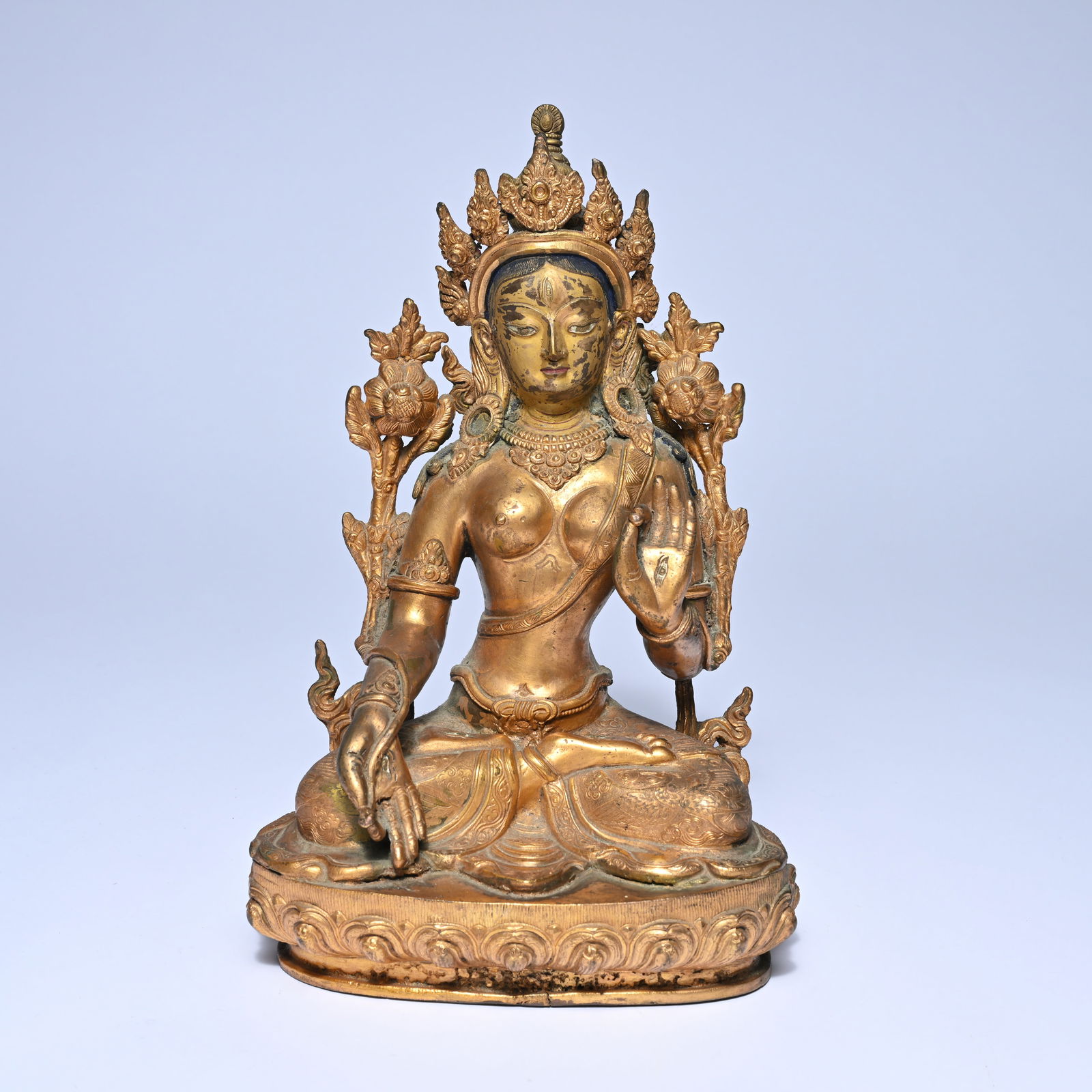 Gilded bronze Buddhist figure Tara, seated in lotus position on a richly decorated lotus base, (1 of 7)