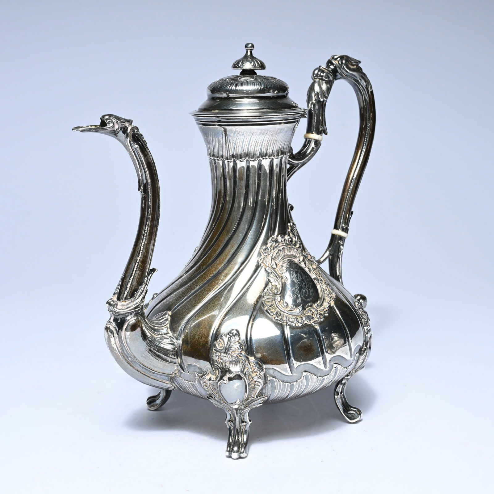 Silver coffee pot with a pear-shaped, twisted body, resting on three graceful feet. It features a (1 of 8)