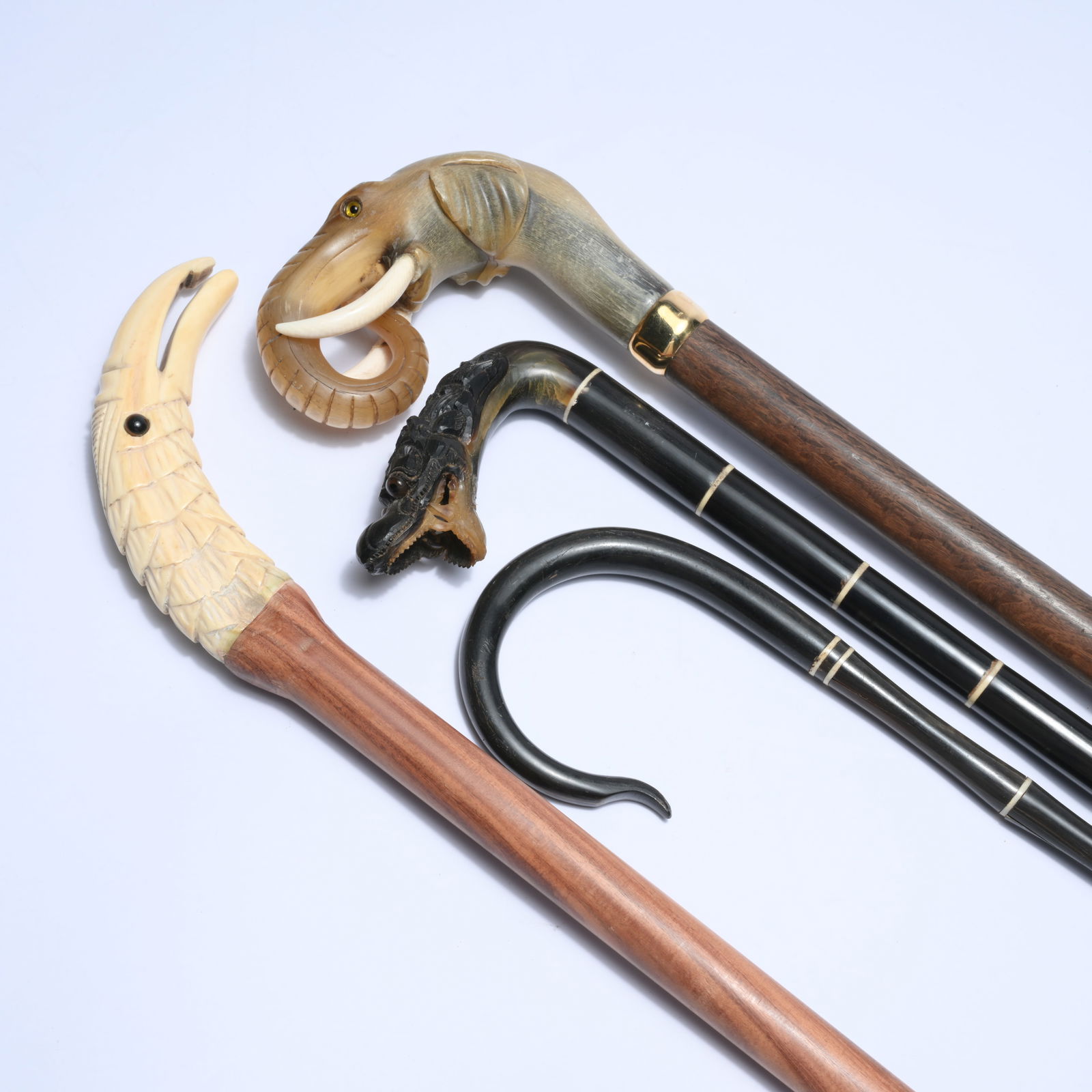 4 walking sticks with striking horn handles (3) in animal motifs including a mythical animal, (1 of 4)