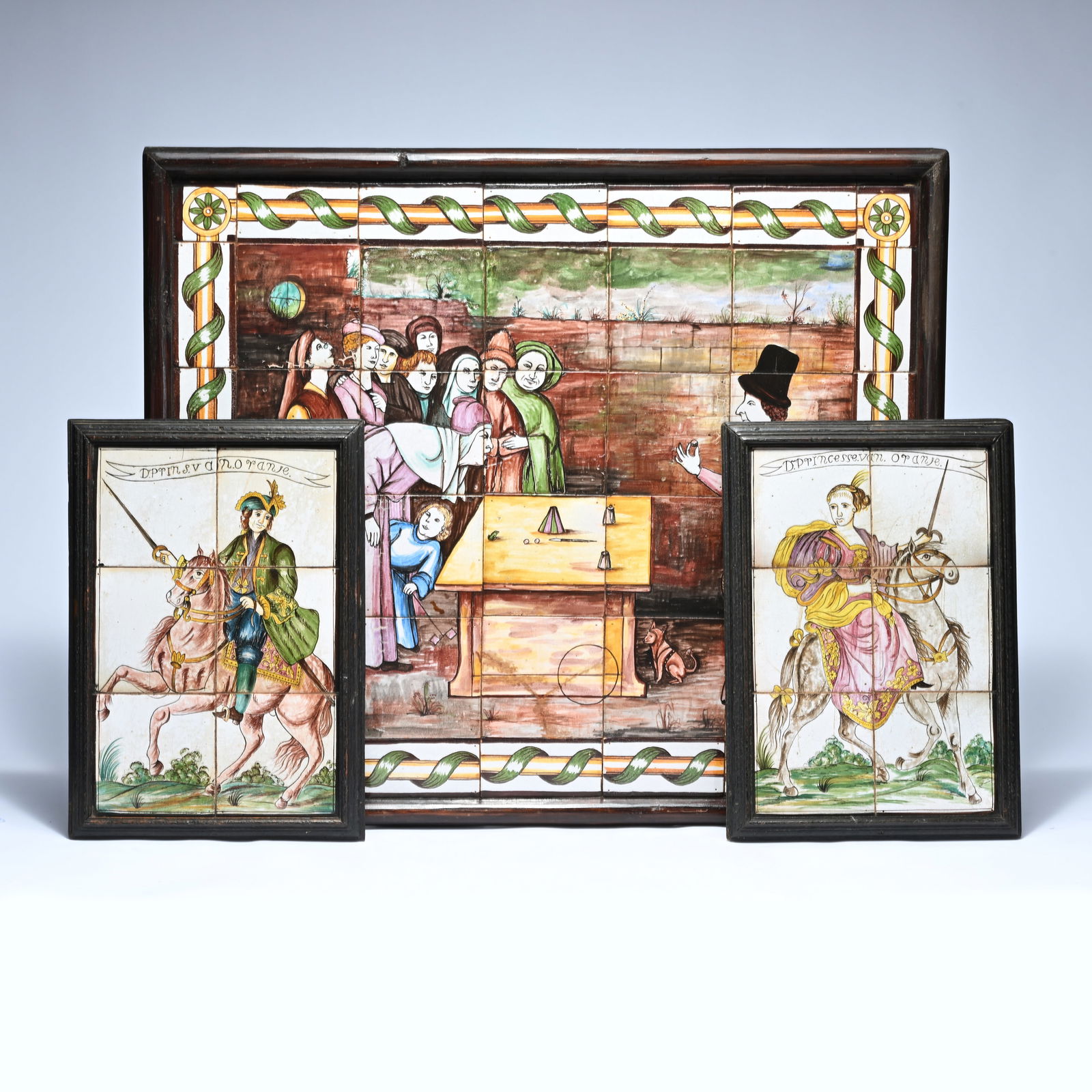 Large tile panel depicting a magician and two tile tableaus with the Prince and Princess of Orange,: Large tile panel depicting a magician and two tile tableaus with the Prince and Princess of Orange, circa 1900, probably Koninklijke Tichelaar MakkumGroot tegelpaneel met voorstelling van een goochela