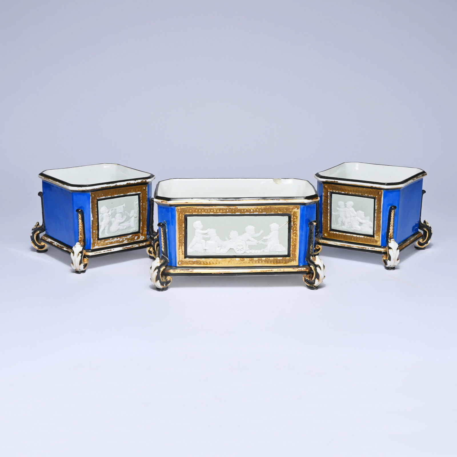 3 19th century Vieux Paris porcelain jardinières, executed in deep cobalt blue porcelain with rich: 3 19th century Vieux Paris porcelain jardinières, executed in deep cobalt blue porcelain with rich gilt decoration and mounted with Wedgwood-style white relief plaques depicting putti and genre scene