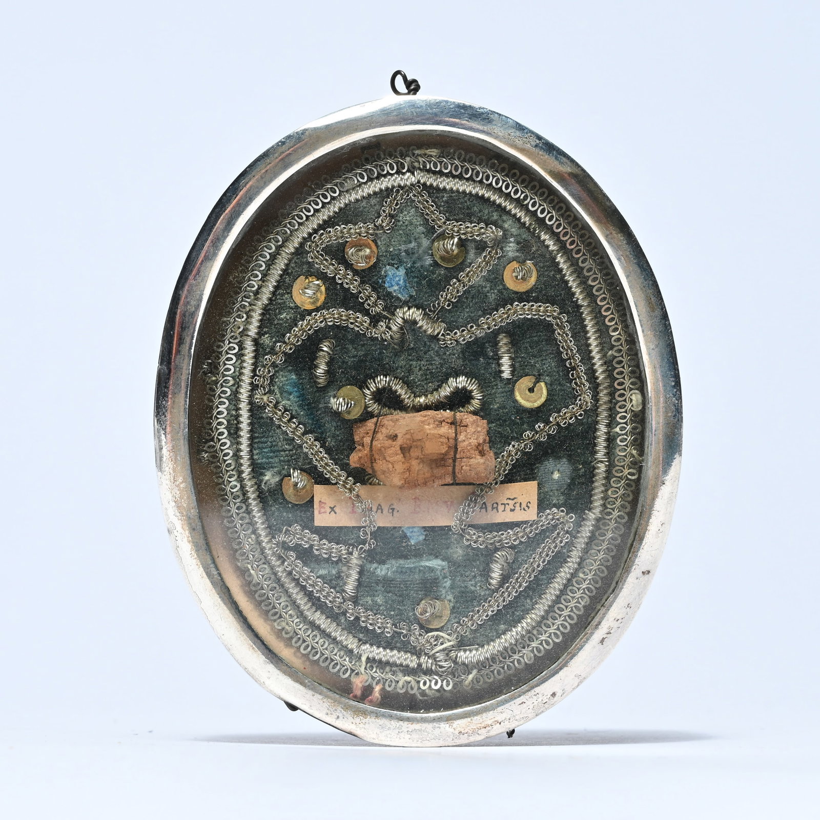 Oval reliquary in copper with a silver rim, with a glass front, richly decorated with decorative (1 of 3)