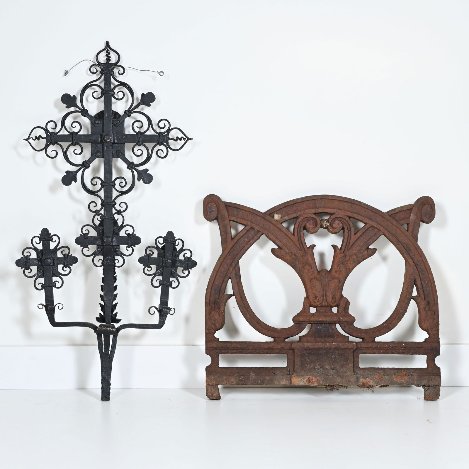 A wrought iron cross and a cast iron ornament in Art Nouveau ironwork.: A wrought iron cross and a cast iron ornament in Art Nouveau ironwork.Een smeedijzeren kruis en een gietijzeren ornament in Art-Nouveau smeedwerk.81 x 40 cm, 46 x 53 cm