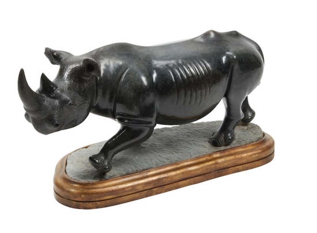 A Large Carved Black Marble Figure of A Rhinoceros on Giltwood Base: A Large Carved Black Marble Figure of A Rhinoceros on Giltwood Base. height 16 1/2in (42cm); width 36in (92cm); depth 11 1/2in (29cm)