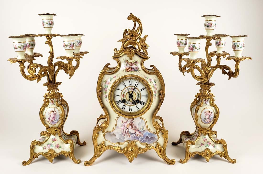 19th C. French Louis XIV Porcelain & Bronze Clockset: 19th C. French Louis XIV Porcelain & Bronze Clockset. The clock measures H: 16 1/2" W: 9 1/4" and the candelabras measure H: 16 1/4" W: 7 1/2"