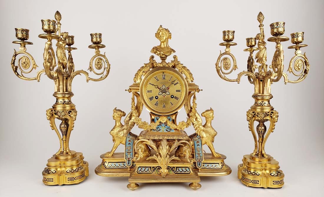 19th C. Tiffany & Co. French Champleve Enamel & Gilt Bronze Figural Clockset: 19th C. Tiffany & Co. French Champleve Enamel & Gilt Bronze Figural Clockset. The clock measures H: 15 1/4" W: 14" and the candelabras measure H: 17" W: 14"