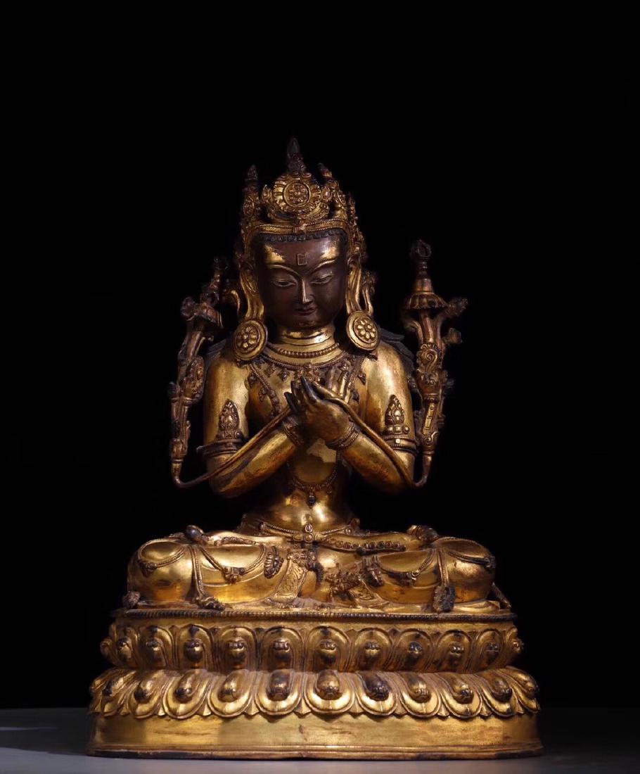 GILT BRONZE CAST BODHISATTVA SEATED FIGURE: The gilt bronze figure depicts Bodhisattva seated on the double lotus throne pad in dhyanasana, hands raised at chest level in mudra, lotus flowers stem upwards from the arms, eyes open in serene expr
