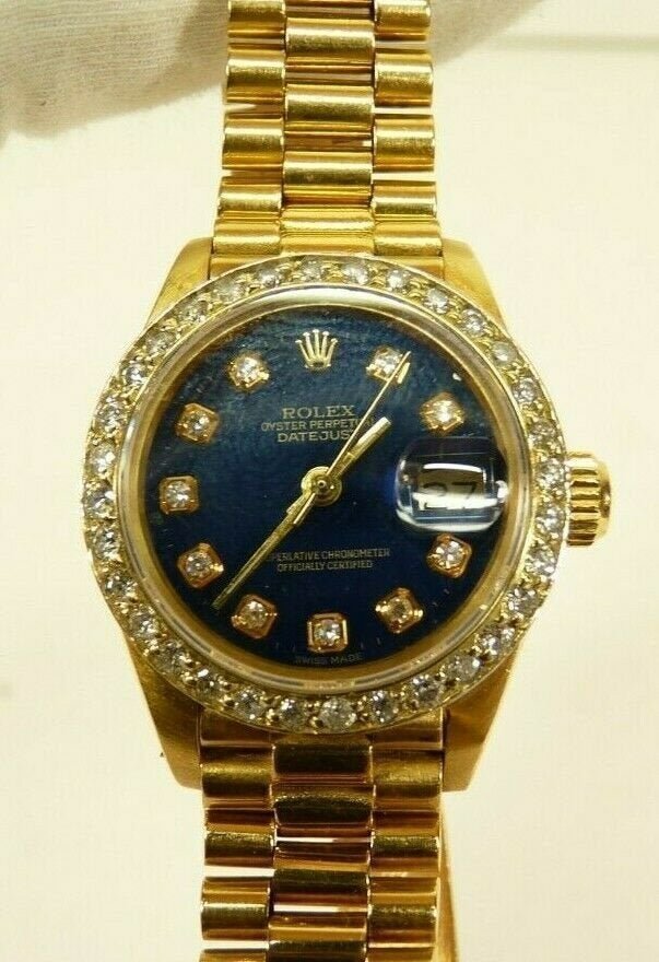 Rolex 18k Yellow Gold President Diamond Bezel Watch: Ladies Rolex Oyster Datejust 6917 18k Yellow Gold President Diamond Bezel Blue Dial 26mm Watch 1978. Weight: 43.3dwt / 67.5g. Band Size: Approximately 5". Total Carat Weight: Approximately 1.30tcw. In