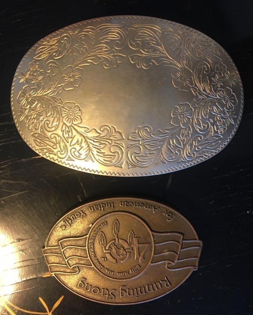 Lot of 2 Belt Buckles Large German Silver & 10K Gold: Lot of 2 Belt Buckles Large German Silver with Floral Design ( measures 5" x 3") and Running Strong For American Indian Youth Billy Mills 10K Gold Medal Anniversary Made in USA measures 3.25" x 2.25".