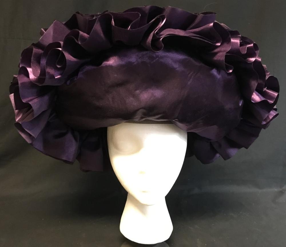 Purple Ruffles Capital Citizen Hat - The Hunger Games: Purple Ruffles Capital Citizen Hat - The Hunger Games Series.; This lot is for a purple ruffled handmade hat worn by a citizen of the capital. It has a basic inner layer with a metal strap to hold on 