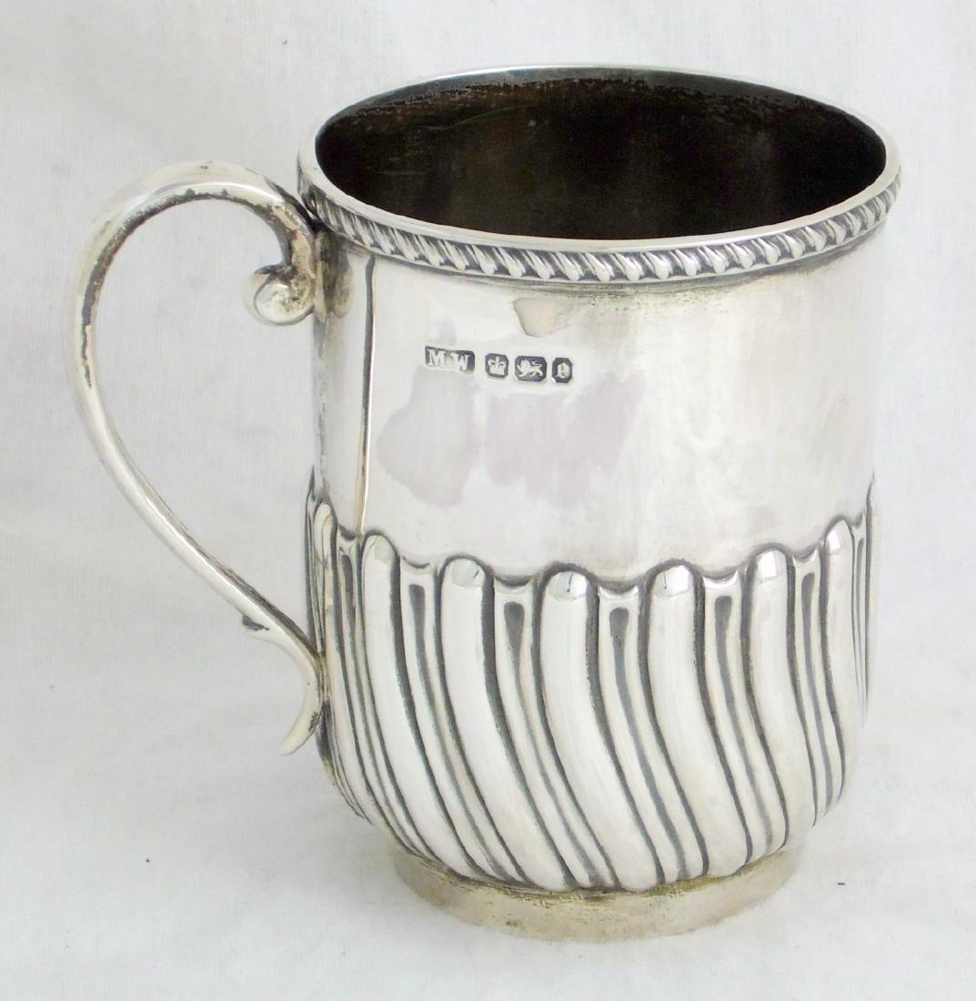 A Victorian Sterling Silver Christening Mug by Mark: A Victorian Sterling Silver Christening Mug by Mark Willis. The body embossed with a lobed band and wrythan fluted decoration and double scroll handle. Hallmarked Sheffield 1897. Height 9 cm. Weight 5