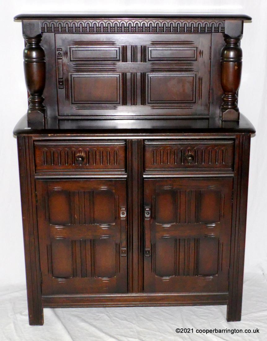 A Small Reproduction Oak Court Cupboard: A Small Reproduction Oak Court Cupboard, possibly Ercol or Priory. Enclosed by an arrangement of cupboards and drawers with panelled and moulded detail. Height 48 in. Width 36 in. Depth 16.5 in