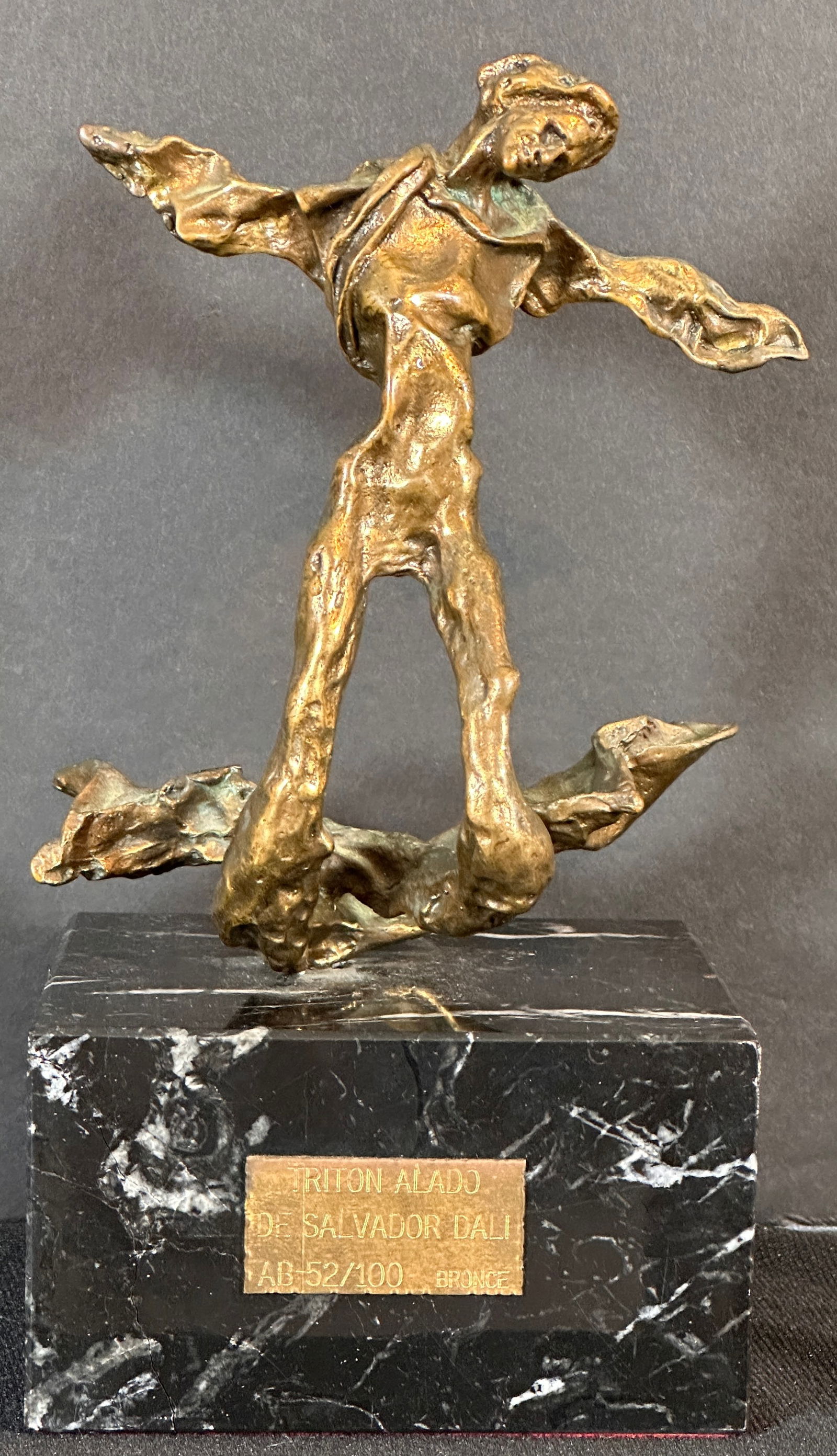 Salvador Dali Winged Triton (Triton Alado) Bronze Sculpture: Artist: Salvador DALI Title: Winged Triton (Triton Alado) Dimensions: Sculpture 6” Sculpture with Base 10.5” Edition: AB 52/100 Medium: Bronze Sculpture with Gold Patina Signature: