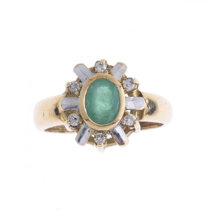 DIAMONDS AND EMERALD ROSETTE RING.: 18kt yellow gold with faceted oval emerald of 6.5x4.5 mm and six brilliant cut diamonds.4.1 grs