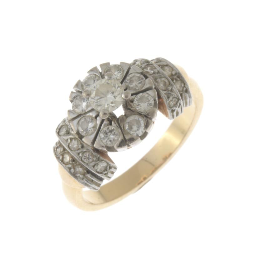 DIAMONDS ROSETTE RING, 1920'S STYLE: Yellow gold and 18 kt white gold views, central diamond of 0.2 ct. approx., bordered with brilliant cut diamonds.Size 12/52Weight: 5.6 gr
