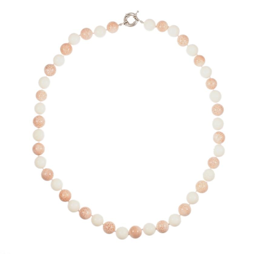 Necklace with white coral beads and angel skin coral.: Beads of 14 to 14.5 mm Silvery metal carabiner clasp. Length when closed: 34 cm.