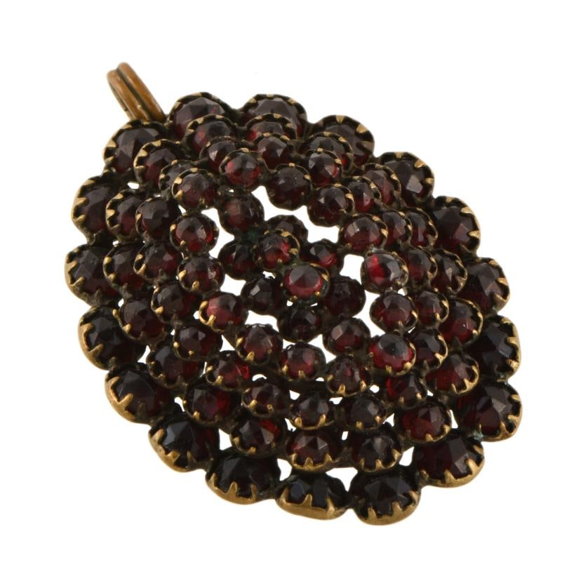 Set comprising a bracelet, pendant and brooch in floral shapes with garnets. (1 of 5)