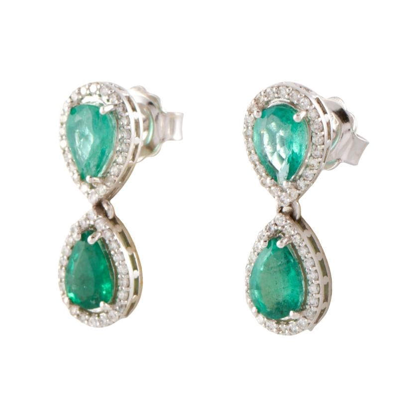 Diamonds and emeralds earrings.: 18 kt white gold. Pear cut emeralds surrounded by brilliant cut diamonds. Pressure clasp.