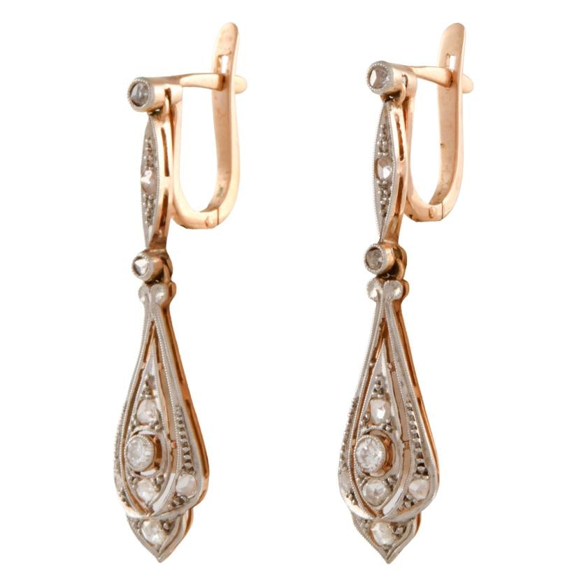 Catalan 'Noucentista' earrings.: 18 kt yellow gold with platinum accents.Brilliant and old cut diamonds.Catalan clasp.Weight: 4.2 gr.