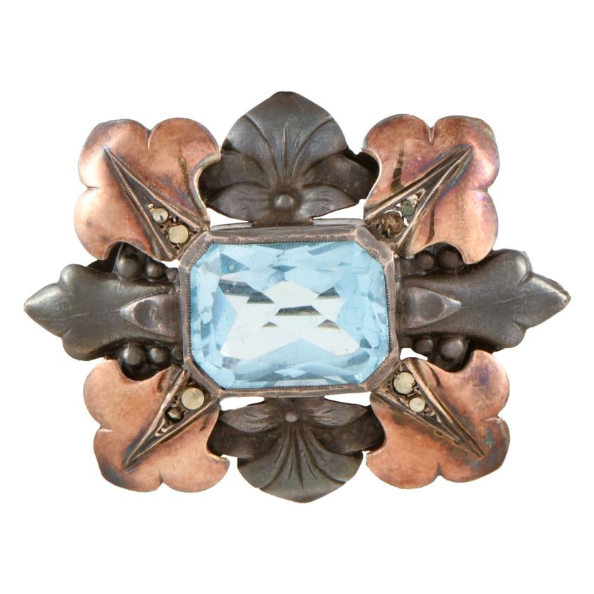 Modernist brooch: 925 silver and over-gilded silver. Emerald cut central topaz, and rhinestones. Weight: 9.9 gr.