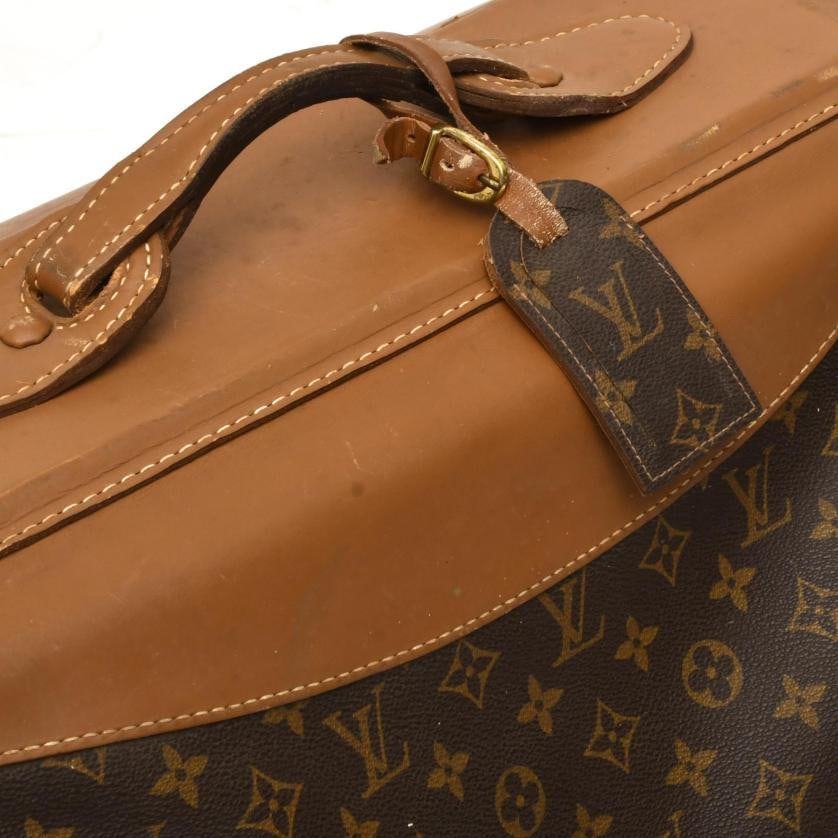 LOUIS VUITTON. Garment bag.: Brown leather with monogram pattern.Wear and tear.59 x 60 x 35 cm (closed); approx. 21 x 128 x 57 cm (open).