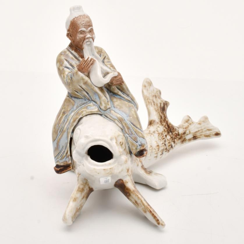 AFTER CHINESE MODELS, Figure of an old man on a Koi, 20th century.: Porcelain, With flaws. 14.5 x 22 x 12 cm approx.